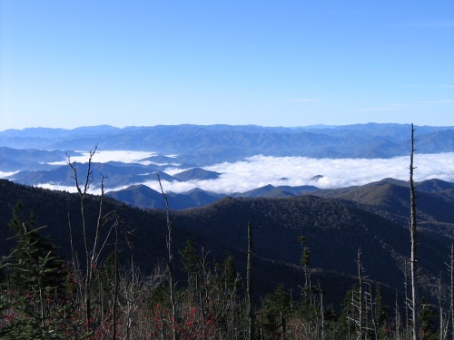 Clouds hang in the valleys below